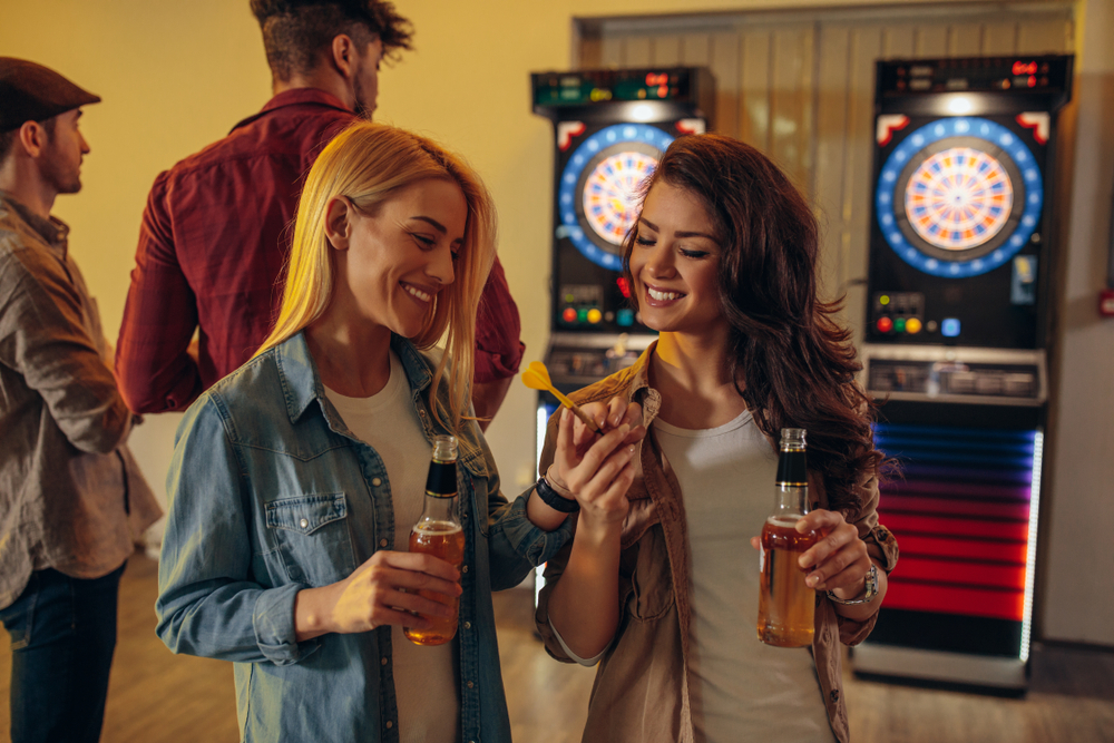 Playing darts: Sports-themed pub crawl: Visit sports bars and compete in pub games. You can organise a sports-themed pub crawl. 