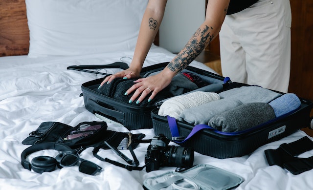 Essential amenities. Woman Packing a Suitcase.
