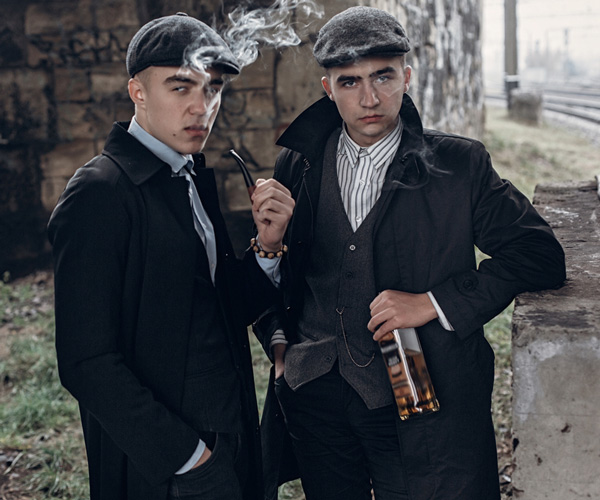 Creating a 1920s gangster atmosphere. Men dressing up in dapper suits and flat caps.